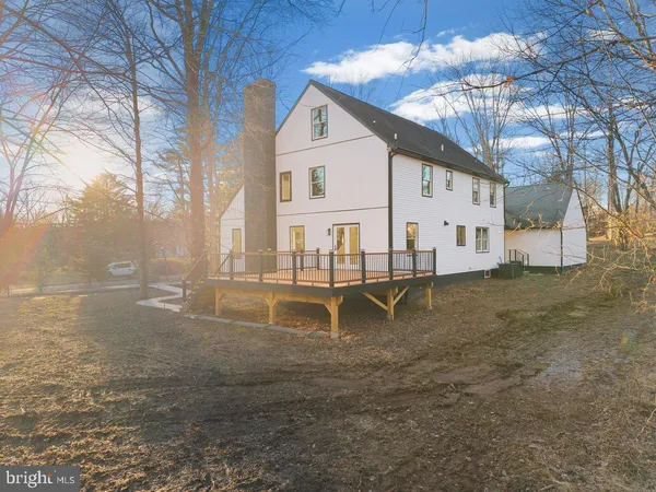 a front view of a building with large trees