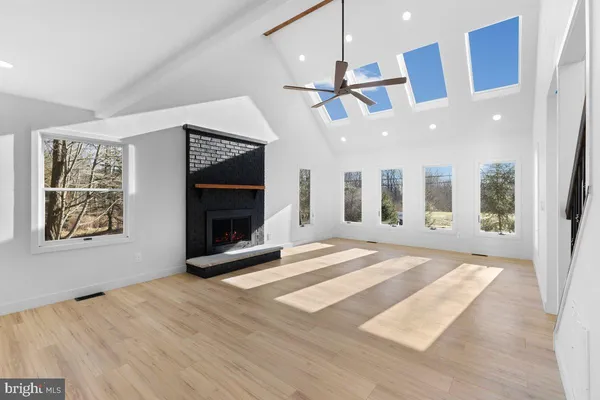 a view of a hallway with wooden floor and a ceiling fan
