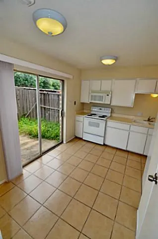 a kitchen with stainless steel appliances a stove a sink and a view of living room