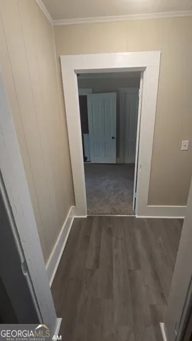 an empty room with wooden floor and entrance