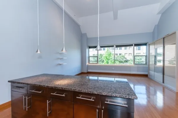 a kitchen with granite countertop a sink and a large window