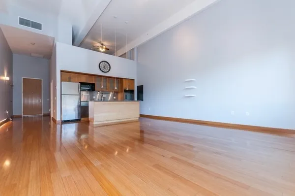a kitchen with stainless steel appliances kitchen island granite countertop a refrigerator and a stove top oven