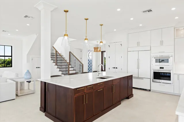 a large kitchen with kitchen island a stove a sink a center island a stove a table and chairs