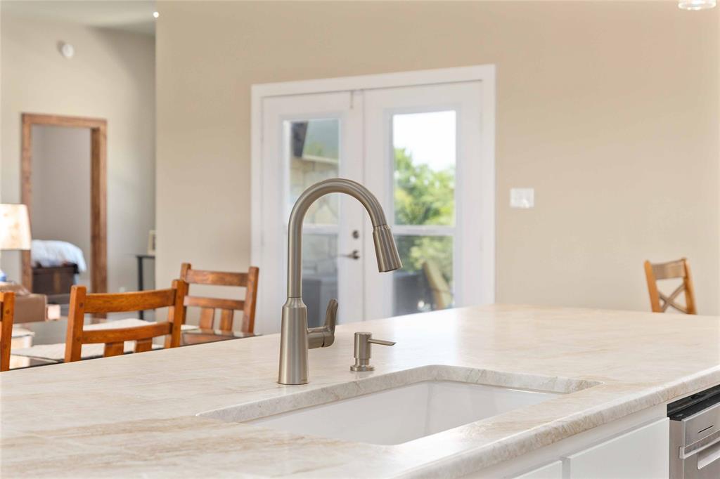 1005 Deep Water Road May, TX 76857 - Photo 18 of 40 Kitchen island with a light-toned countertop, undermount sink, and gooseneck faucet