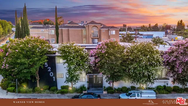front view of a house with a yard and potted plants