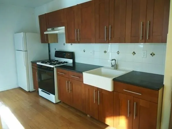 a kitchen with granite countertop a sink stove and cabinets