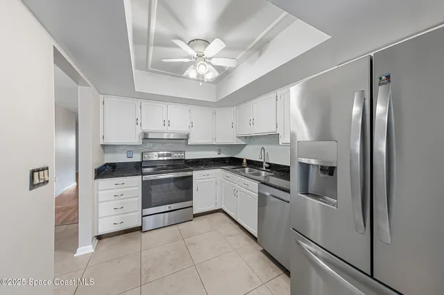 a kitchen with stainless steel appliances a refrigerator sink and cabinets