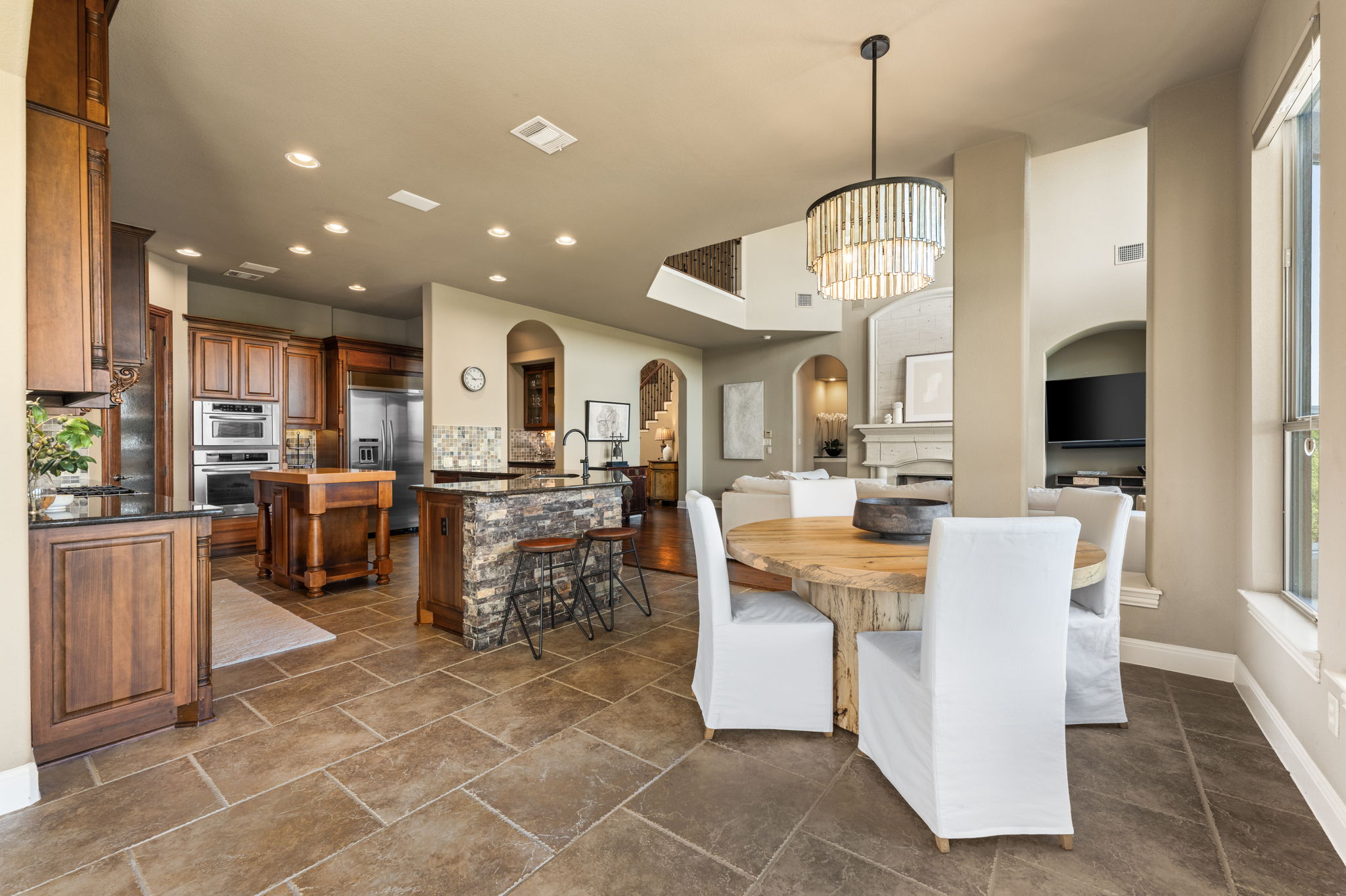 205 Emerald Ridge Drive Austin, TX 78732 - Photo 11 of 40 a view of a dining room with furniture a kitchen and chandelier