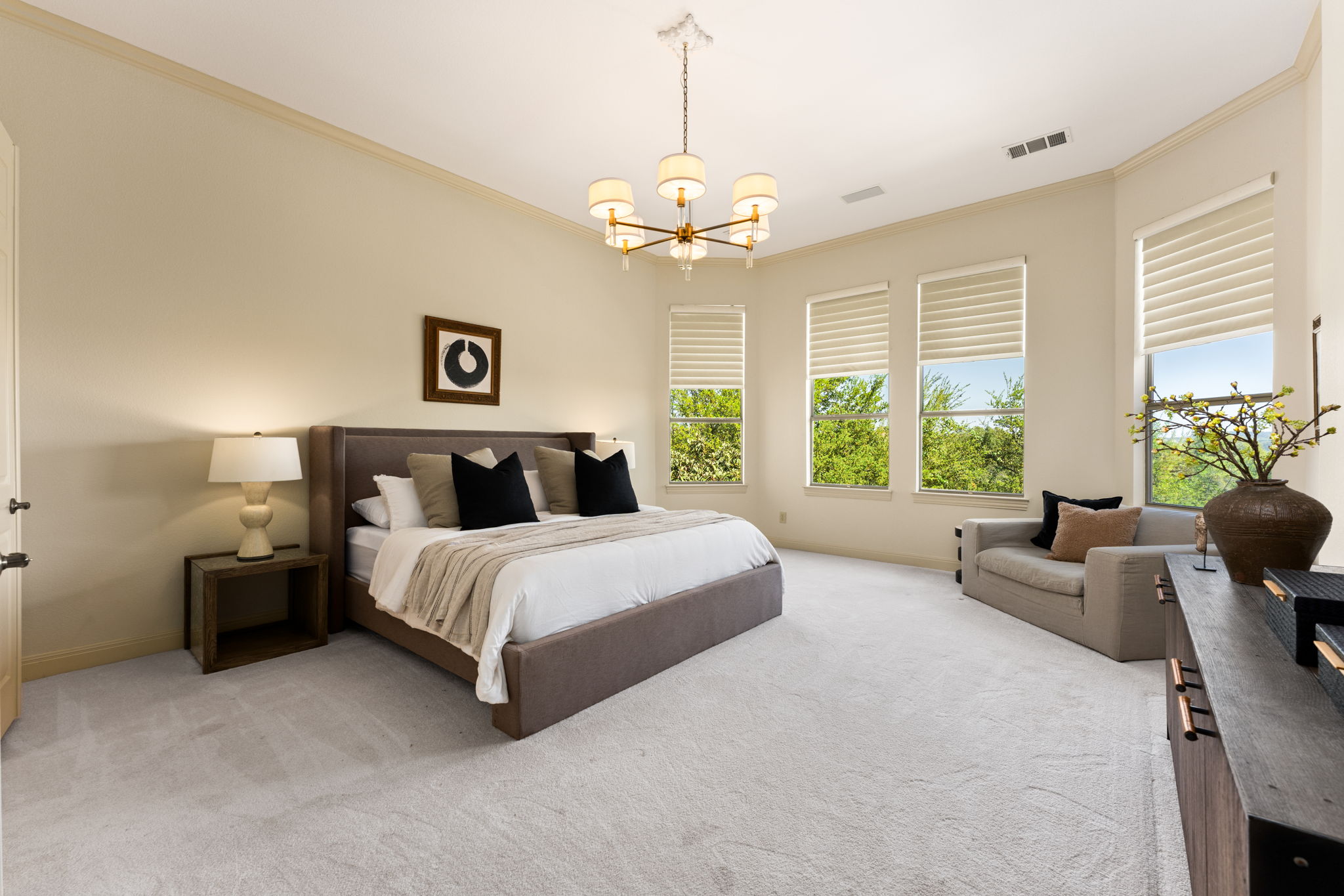 205 Emerald Ridge Drive Austin, TX 78732 - Photo 15 of 40 a spacious bedroom with a bed and a chandelier