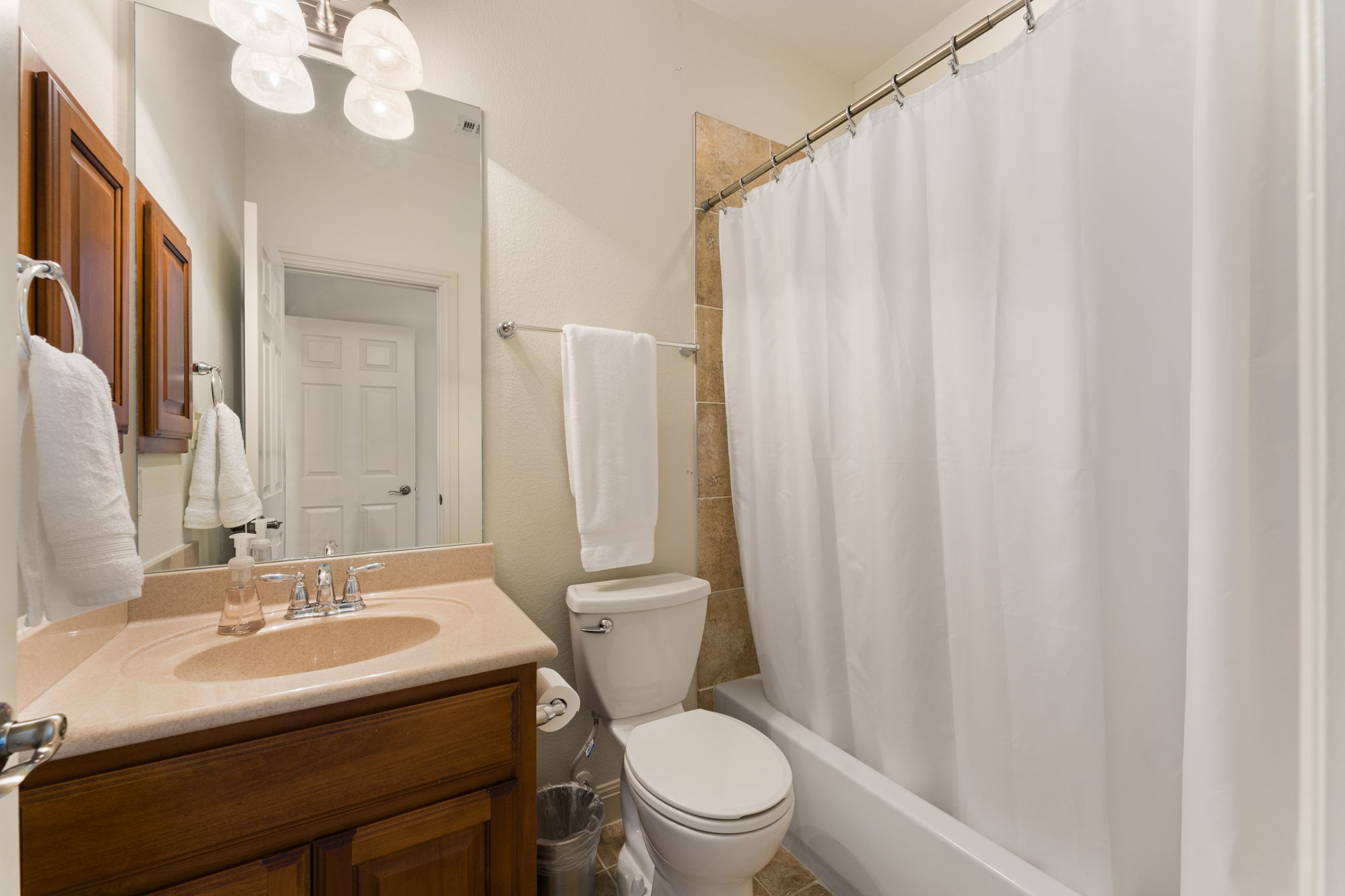 205 Emerald Ridge Drive Austin, TX 78732 - Photo 27 of 40 a bathroom with a sink a toilet and a mirror