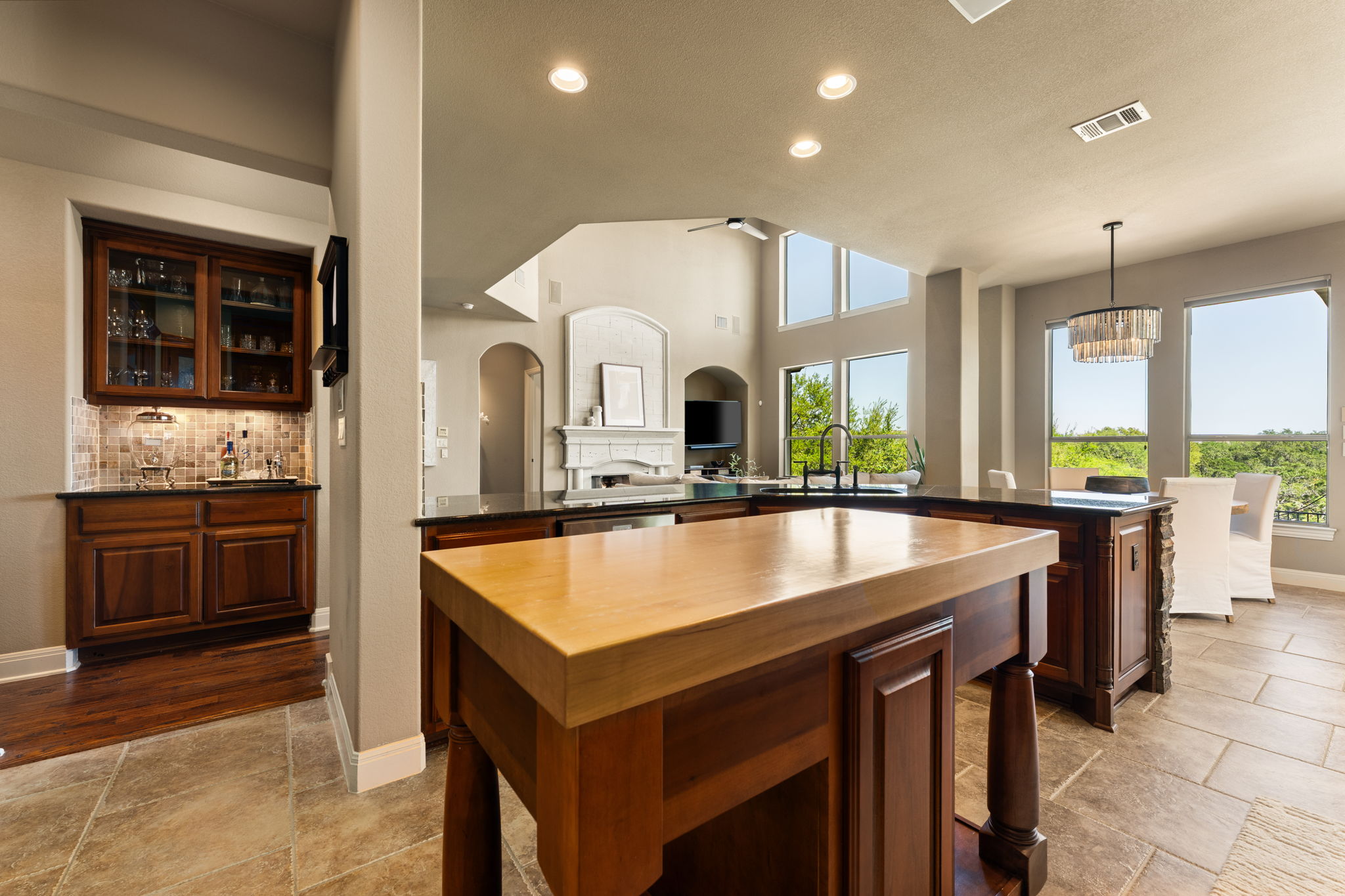 205 Emerald Ridge Drive Austin, TX 78732 - Photo 10 of 40 a large kitchen with kitchen island a large counter top space a sink stainless steel appliances and windows