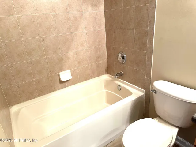 a bathroom with a toilet and bathtub