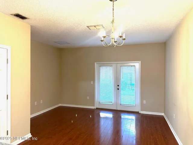 a view of a room with wooden floor and chandelier