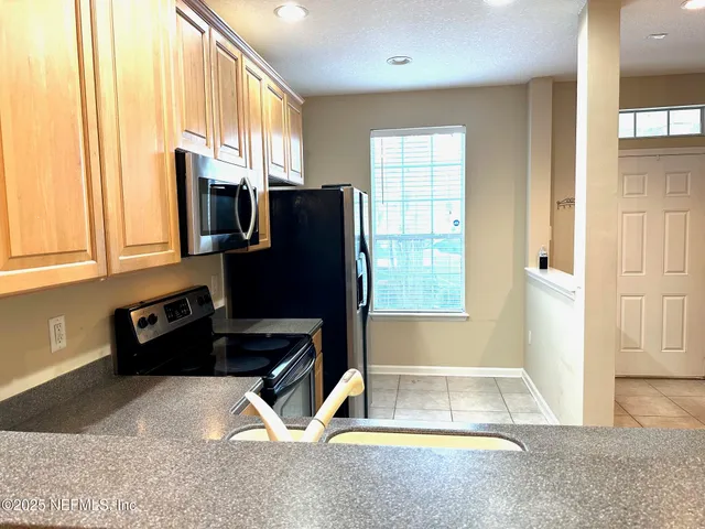 a kitchen with granite countertop a refrigerator and a sink