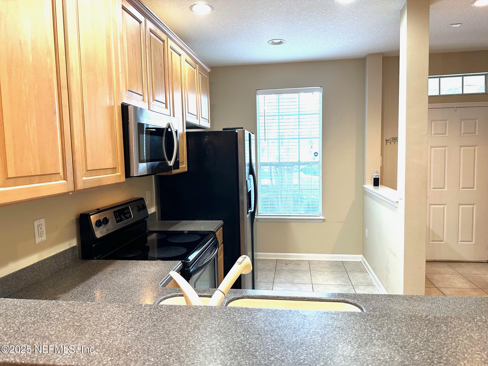 1523 Fieldview Drive Jacksonville, FL 32225 - Photo 9 of 23 a kitchen with granite countertop a refrigerator and a sink