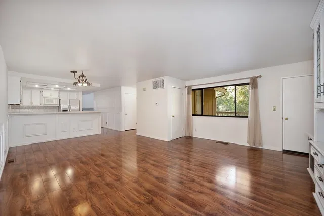 a view of an empty room with wooden floor