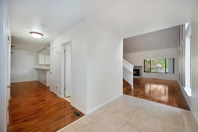 a view of empty room with wooden floor and fireplace