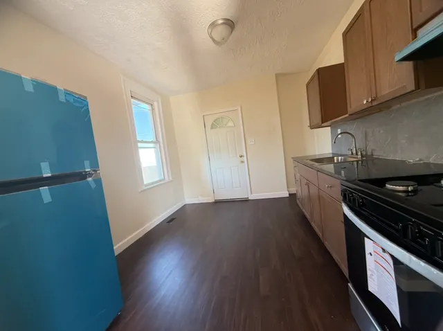 a kitchen with granite countertop wooden floors and stainless steel appliances