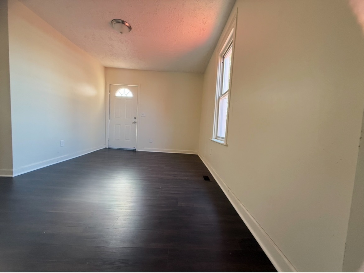 26 Clarence Street, Unit 1 Bridgeport, CT 06608 - Photo 13 of 21 an empty room with wooden floor and windows