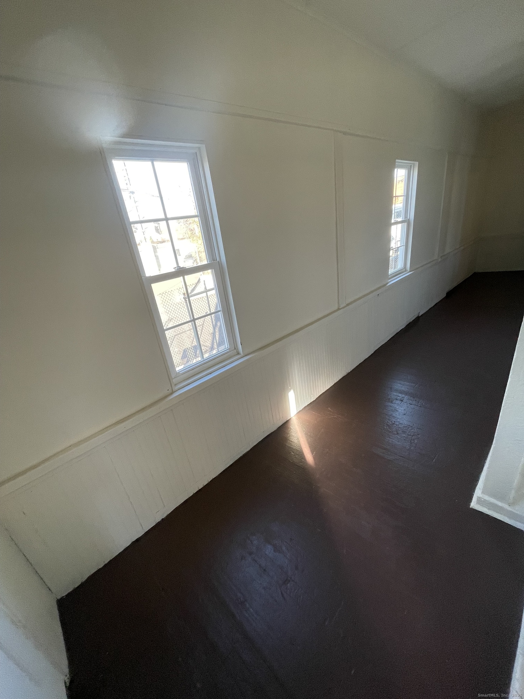 26 Clarence Street, Unit 1 Bridgeport, CT 06608 - Photo 17 of 21 an empty room with wooden floor and windows