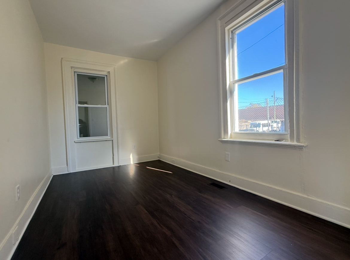 26 Clarence Street, Unit 1 Bridgeport, CT 06608 - Photo 4 of 21 a view of an empty room with wooden floor and a window
