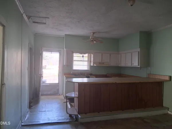 a kitchen with a wooden floor and cabinets