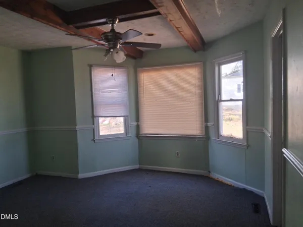 an empty room with a window and a ceiling fan