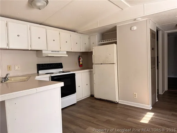 a kitchen with white cabinets and white appliances