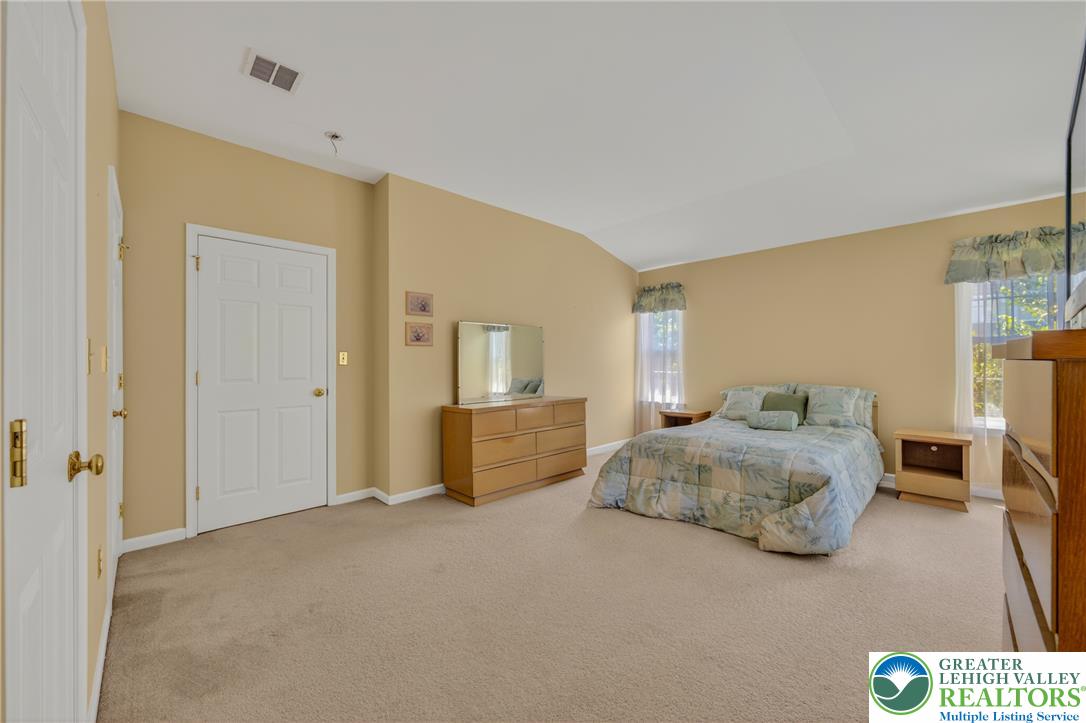 4345 Creek Road Allentown, PA 18104 - Photo 19 of 33 A naturally illuminated primary bedroom offers spacious living with vaulted ceilings and ample room for furnishings.