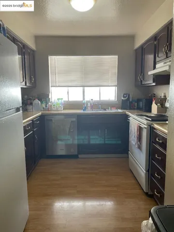 a kitchen with stainless steel appliances granite countertop a sink and wooden cabinets