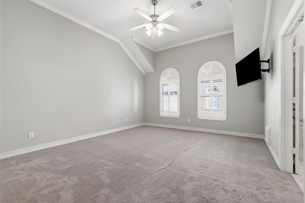 2615 Colby Street, Unit B Dallas, TX 75204 - Photo 20 of 39 3rd floor primary bedroom with ceiling fan and plantation shutters. TV stays