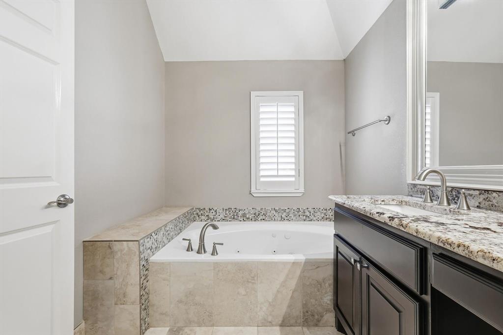 2615 Colby Street, Unit B Dallas, TX 75204 - Photo 24 of 39 Primary Bathroom with a jetted tub, vanity, and lofted ceiling