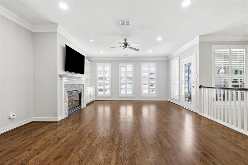 2615 Colby Street, Unit B Dallas, TX 75204 - Photo 8 of 39 2nd level living room featuring wood flooring, ceiling fan, crown molding, recessed lighting, gas stone fireplace, TV stays.