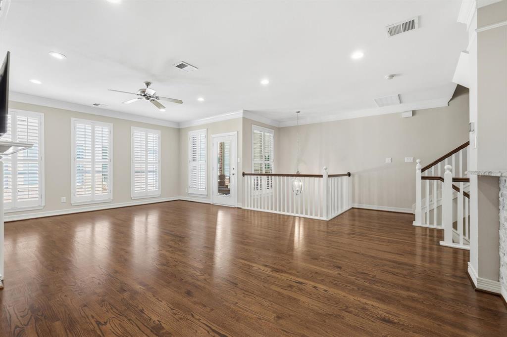 2615 Colby Street, Unit B Dallas, TX 75204 - Photo 9 of 39 2nd level living room featuring wood flooring, open stairway railings, ceiling fan, plantation shutters.