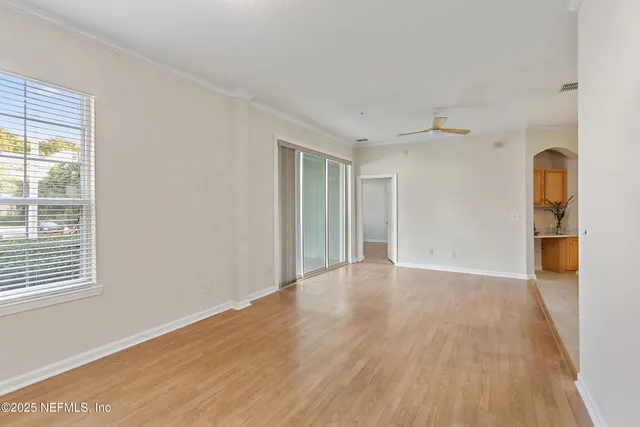 a view of a livingroom with wooden floor and a bathroom
