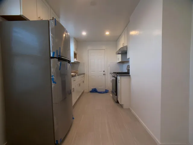 a view of a refrigerator in kitchen and a sink