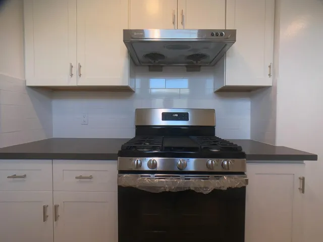 a stove top oven sitting inside of a kitchen