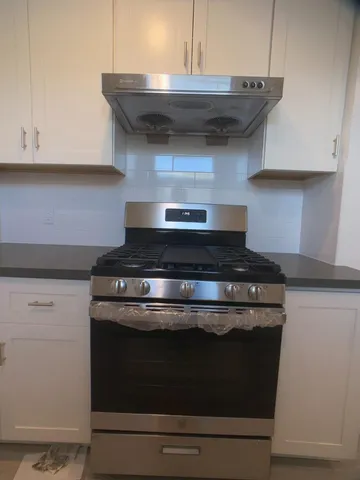 a stove top oven sitting inside of a kitchen