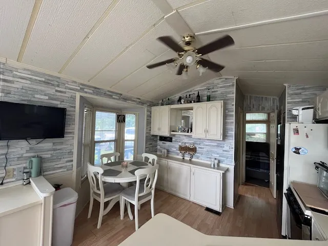 a kitchen with stainless steel appliances kitchen island granite countertop a stove top oven a sink a dining table and chairs