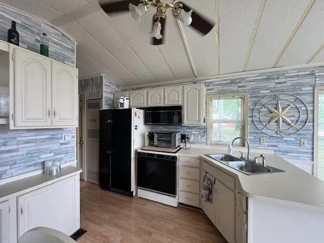 a kitchen with stainless steel appliances kitchen island granite countertop a sink and refrigerator