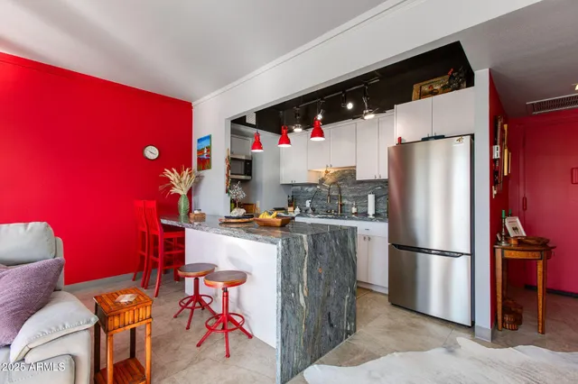 a kitchen with stainless steel appliances granite countertop a refrigerator and a stove top oven