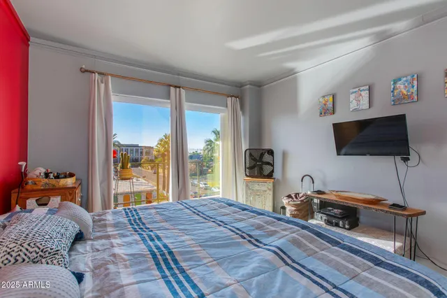 a bedroom with a bed and a flat tv screen