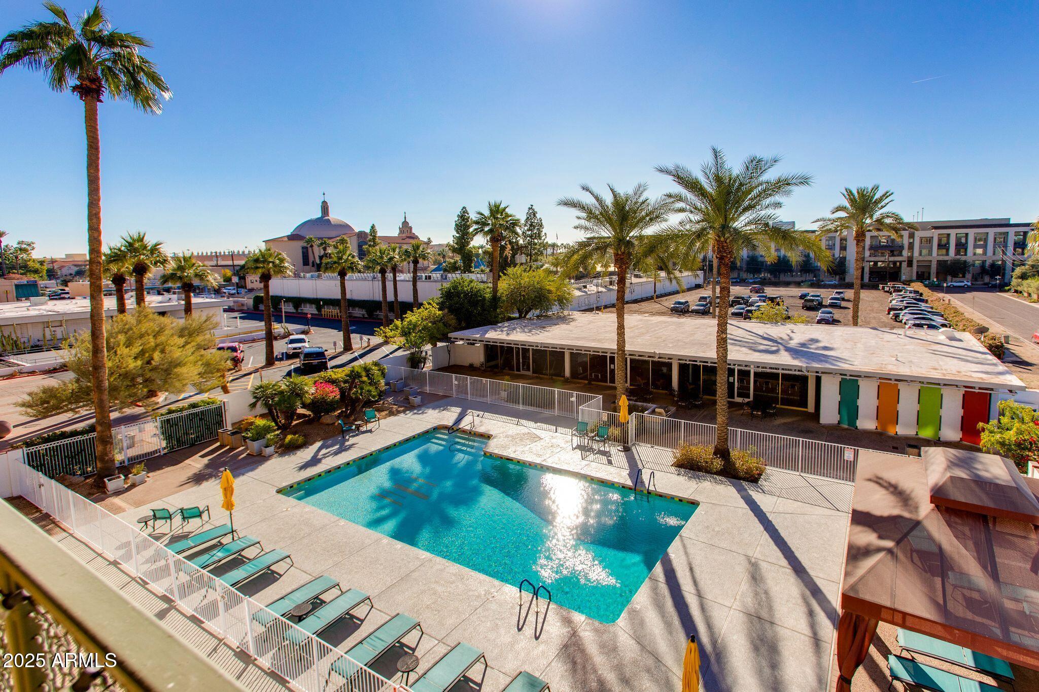 4750 North Central Avenue, Unit 3J Phoenix, AZ 85012 - Photo 10 of 11 a view of a swimming pool with a lawn chairs under an umbrella