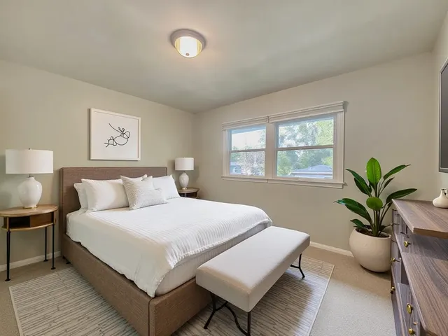 a bedroom with a large bed and a potted plant