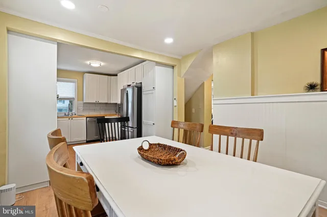 a kitchen with a table chairs refrigerator and cabinets