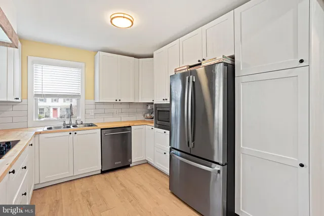 a kitchen with stainless steel appliances granite countertop a refrigerator and a sink