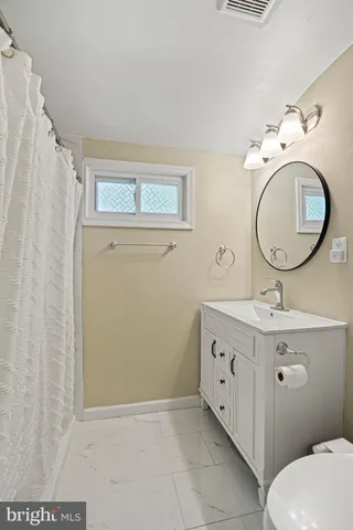 a bathroom with a granite countertop toilet sink and mirror