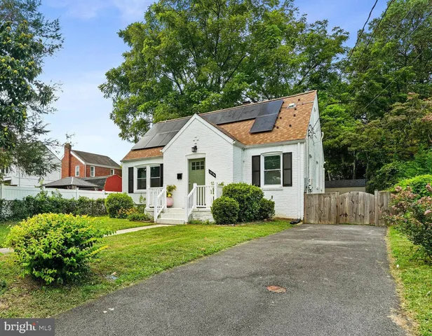 a front view of a house with a yard and potted plants