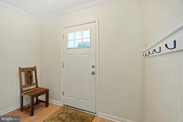 a view of a bedroom with wooden floor and white walls
