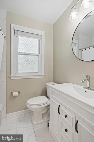 a bathroom with a sink a toilet and a mirror